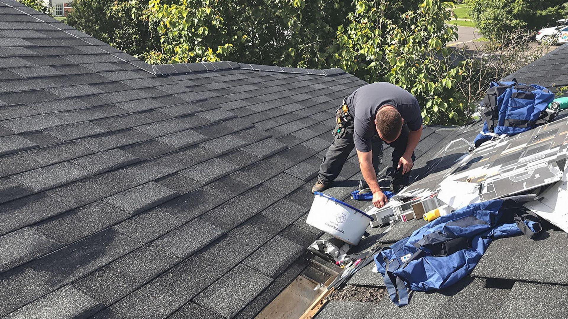 Roof maintenance checklist — technician inspecting shingles and flashing on a New Jersey home